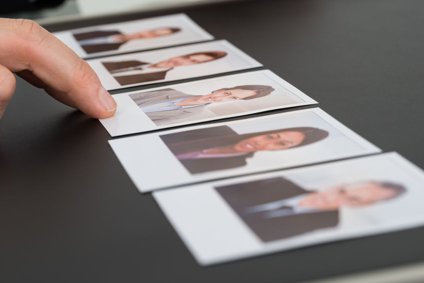 Close-up Of A Person's Hand Choosing Photograph Of A Candidate