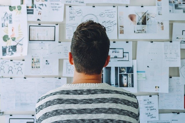 Man looking at pinned papers to build a successful mentoring relationship.