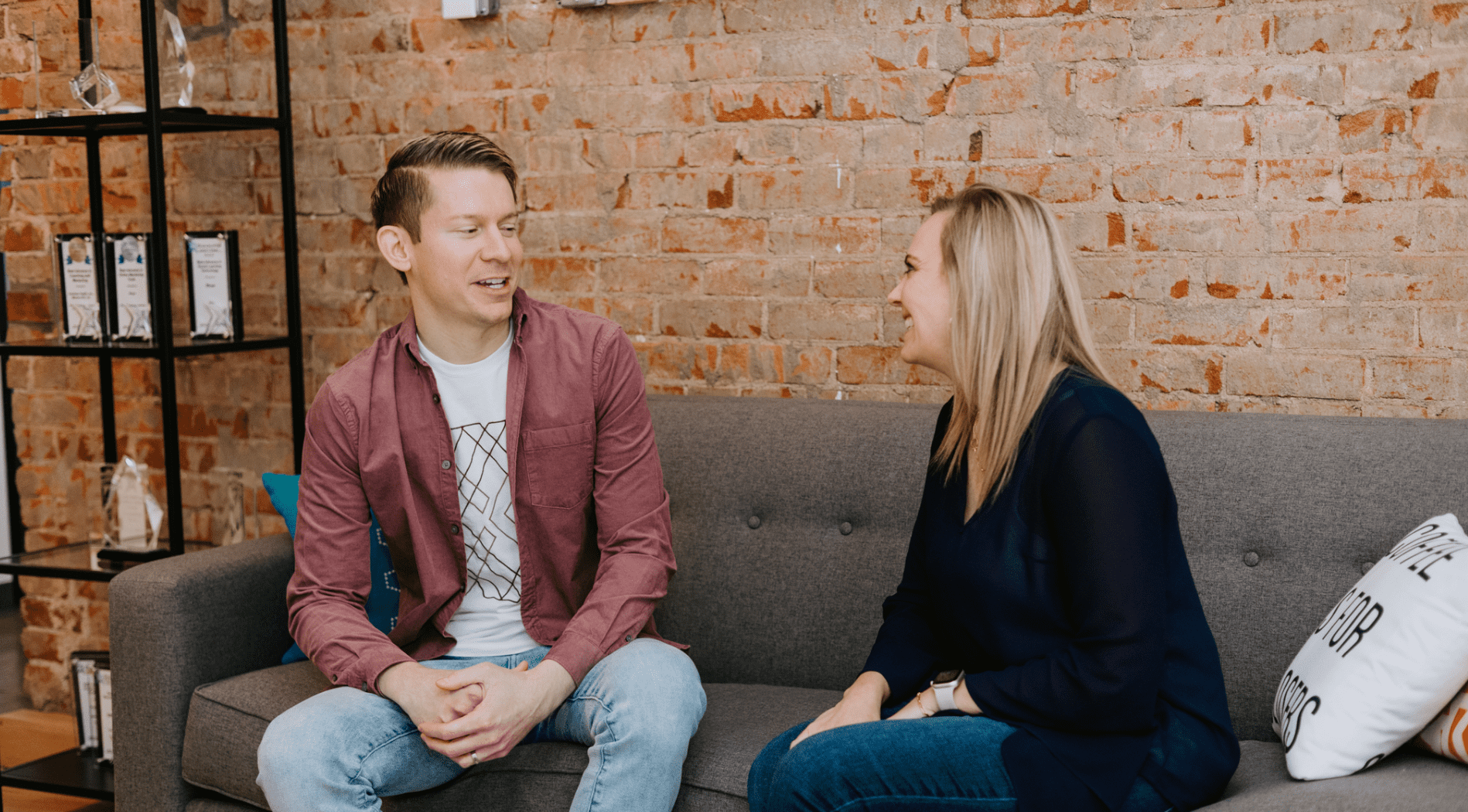 Man and woman sitting on a couch engaging in a mentoring discussion.