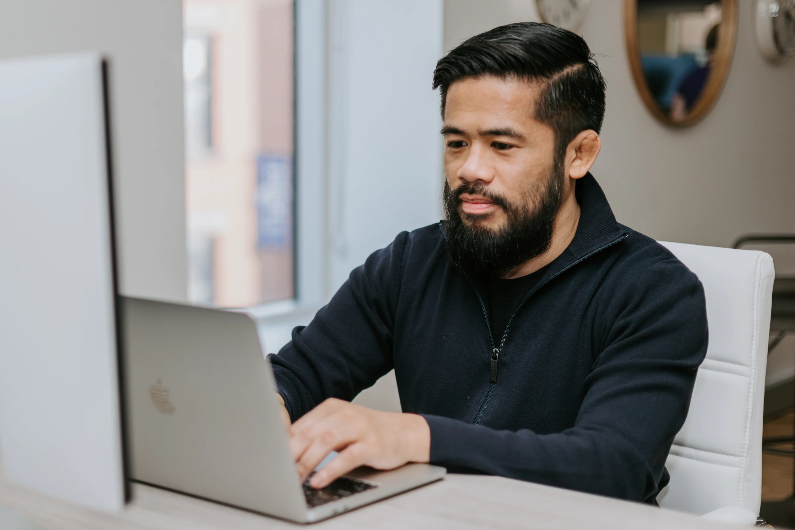 Worker at a table typing on a computer about career aspirations.