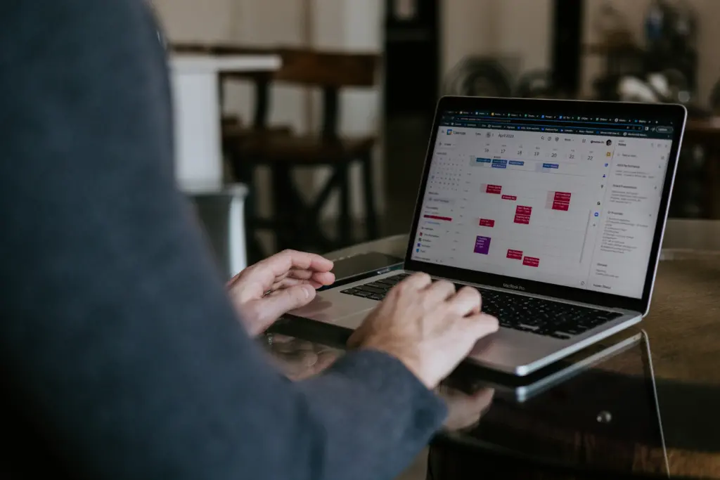 Image of a leader sitting at a computer with a calendar open on the screen.