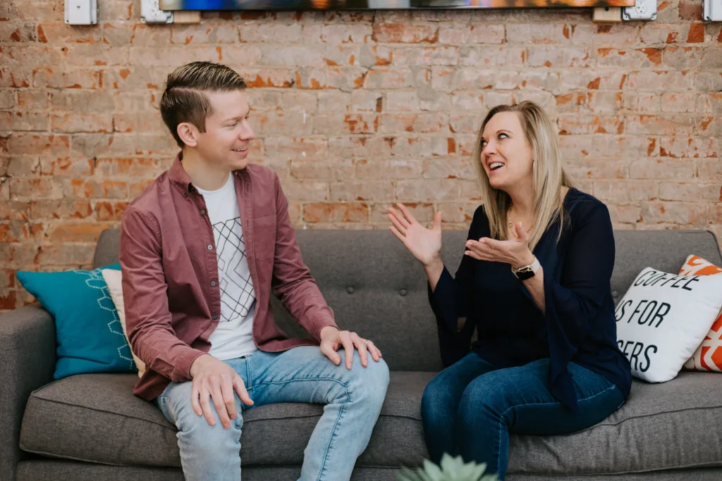 Man and woman on a couch discussing career mentoring advice.