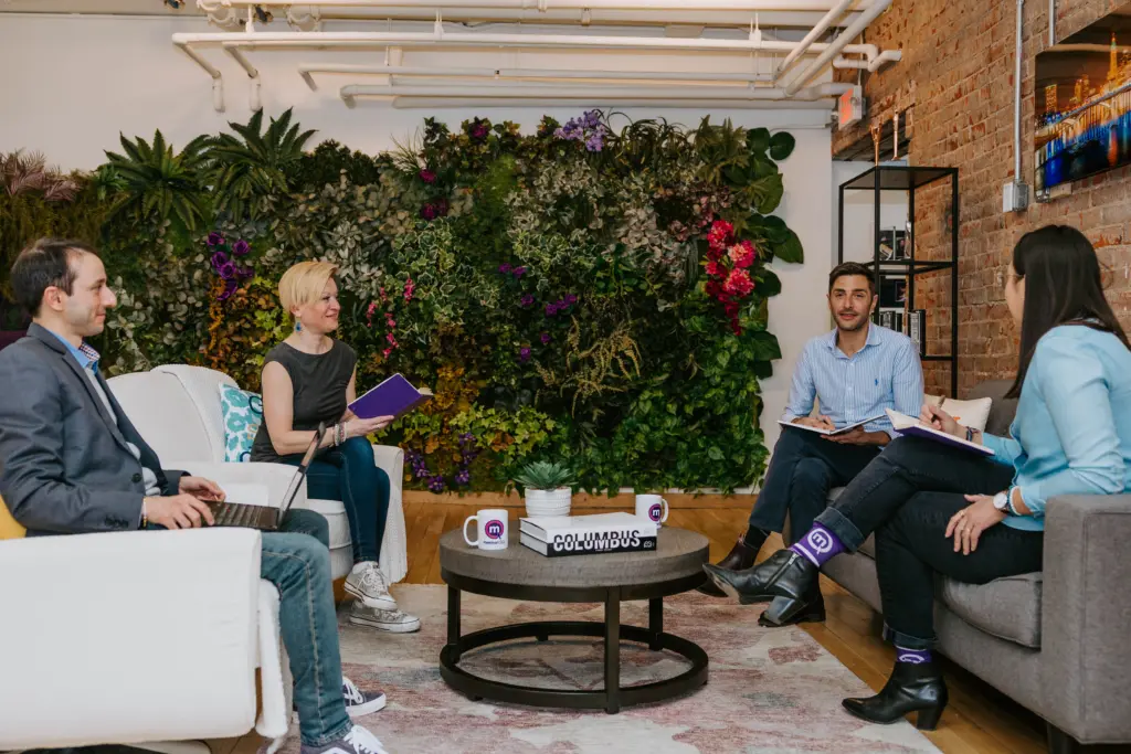 A group of workers in an office at a mentor network gathering. 