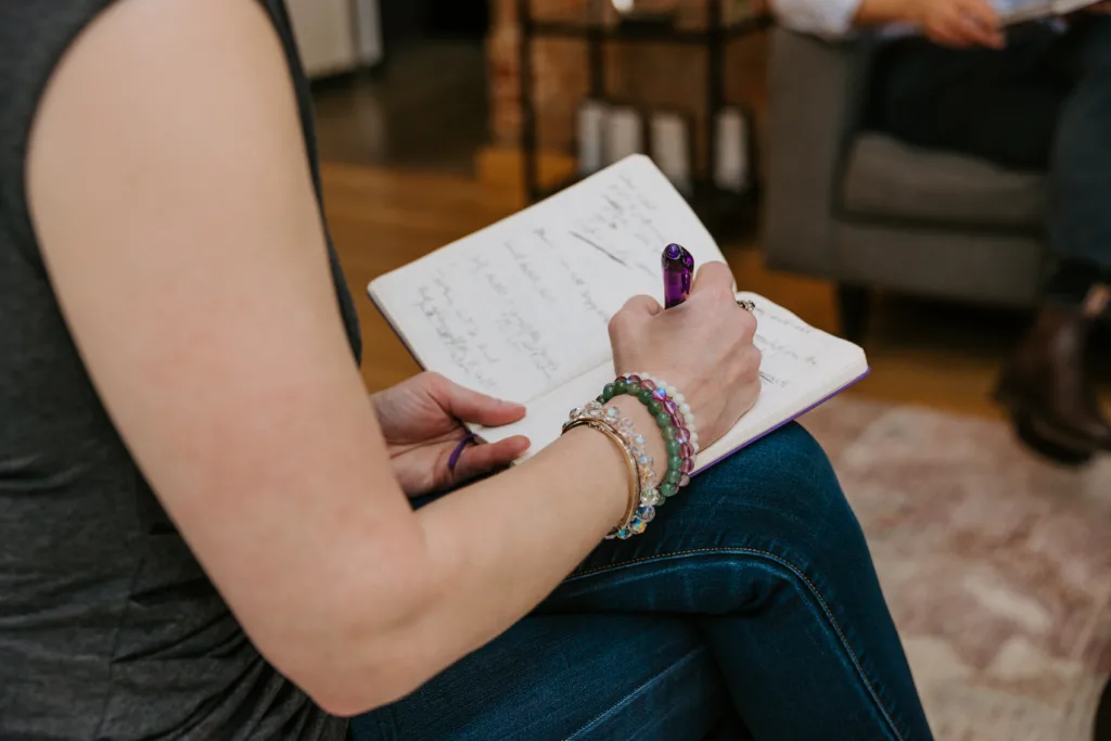 Woman writing in a journal about her leadership styles. 