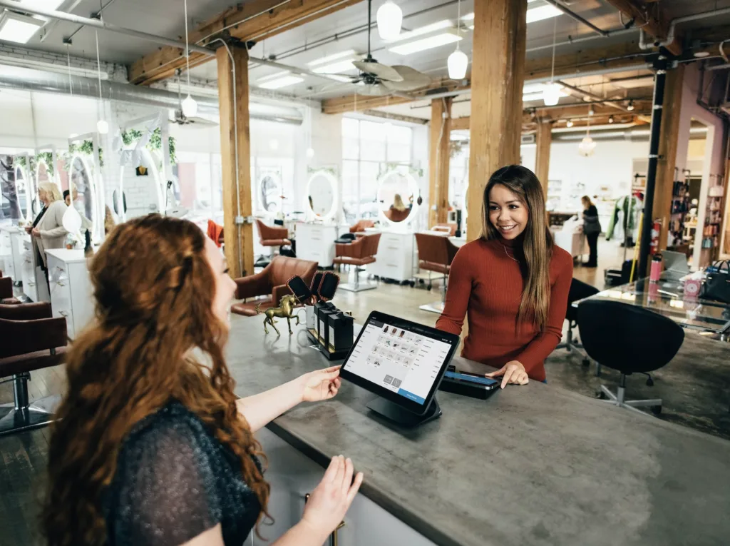 A Mentor and Mentee in a meeting sitting at a table in an open office environment. 