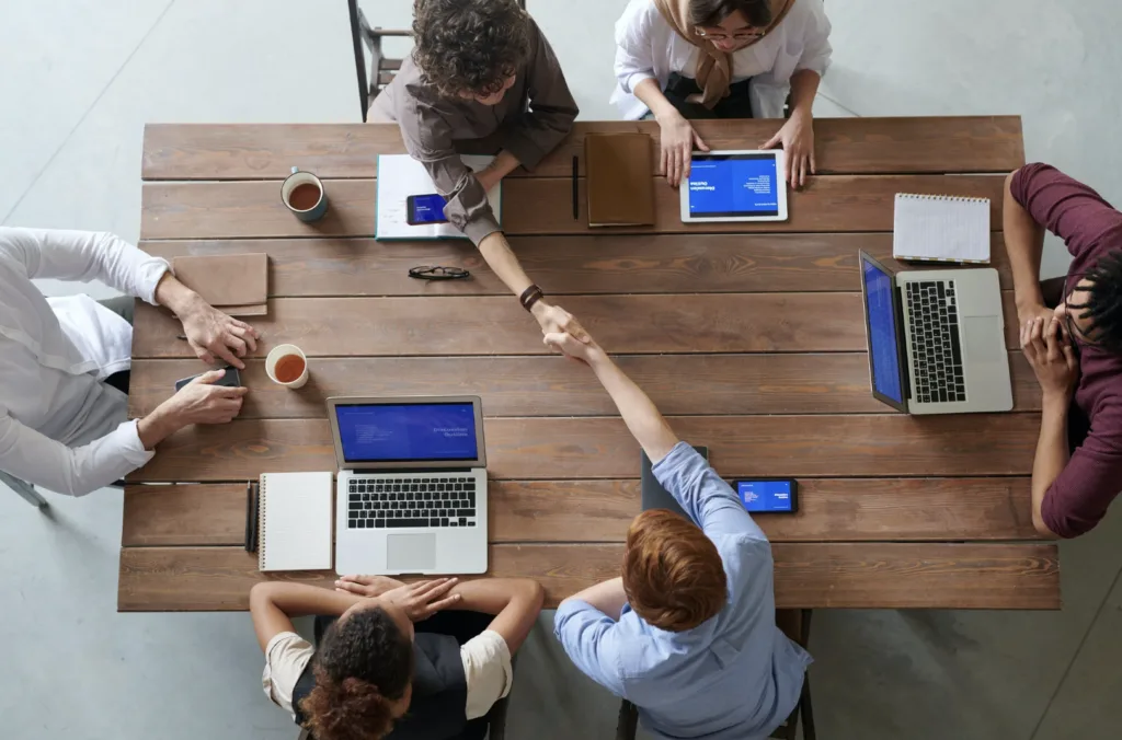 Shaking hands across a table in mentorship programs