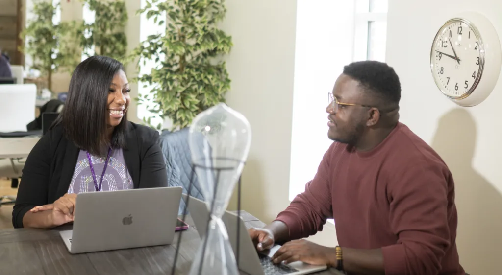 Man and woman in an office discussing mentor-mentee topics. 