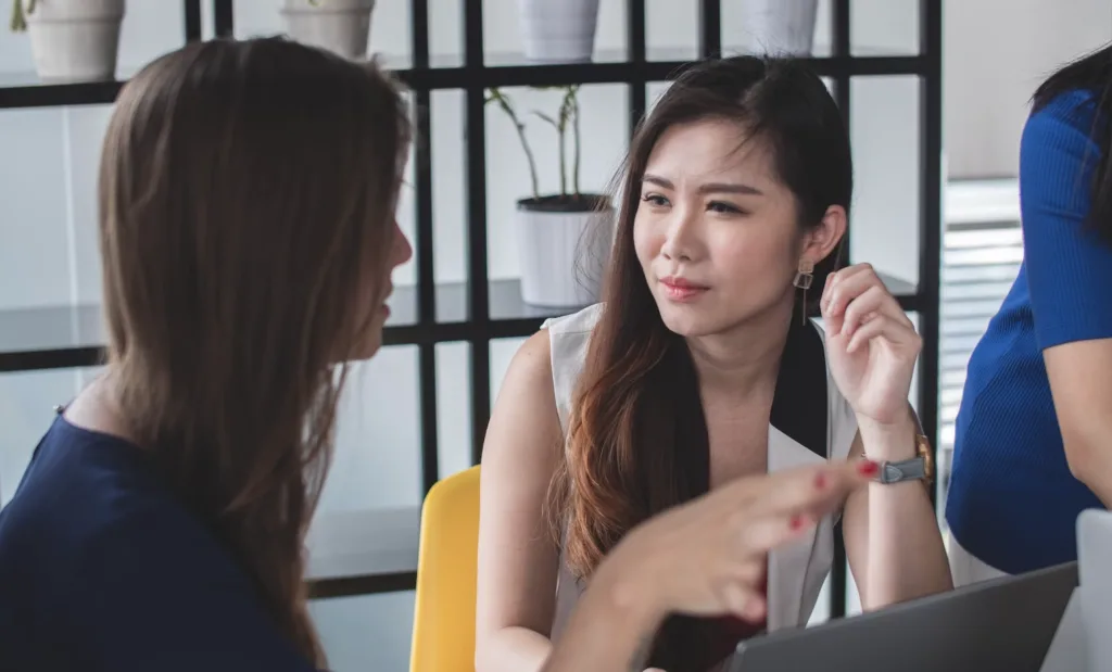 Two women in an office setting in deep conversation. 