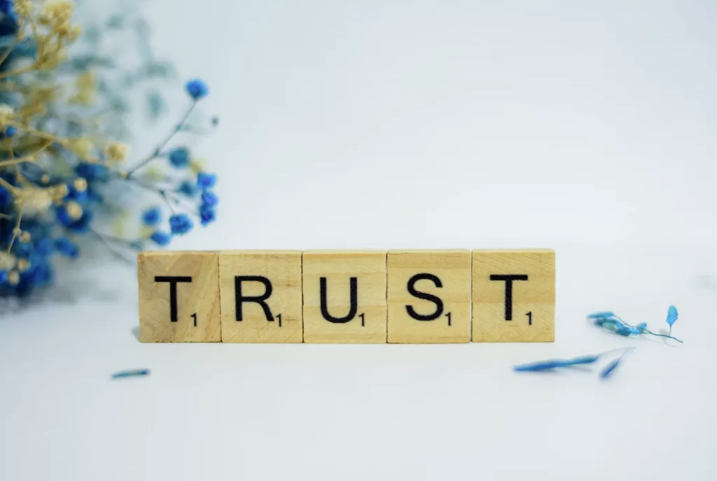 Wooden scrabble game pieces that spell the word trust.