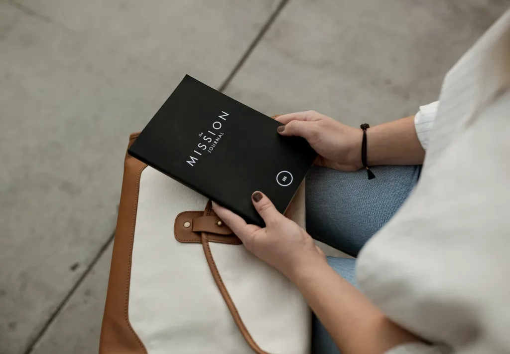 A person holding a mission journal that will be used to write a vision statement as a mentoring activitiy.